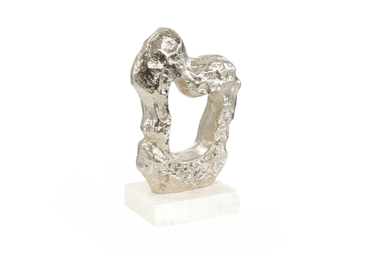 Escultura de Metal Plateada con Hueco y Textura sobre Base de Mármol Blanco